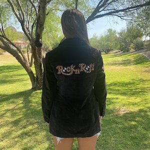 May include: A black corduroy jacket with a leopard print "Rock N Roll" design on the back.