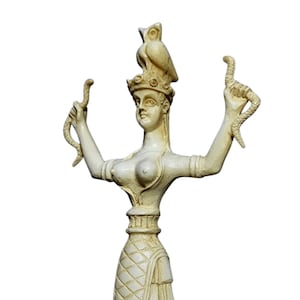 Peut inclure: Une statue en céramique blanche représentant une figure féminine avec un hibou sur la tête et des serpents dans les mains. La statue est debout et présente un design détaillé.