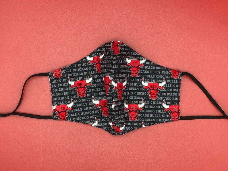 May include: Black face mask with a repeating pattern of the Chicago Bulls logo and the text "Chicago Bulls".