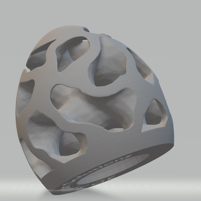 Puede incluir: Un objeto gris impreso en 3D con un dise&ntilde;o hueco e intrincado que se asemeja a un panal de abejas o una estructura porosa. El objeto tiene la forma de un huevo o una esfera con una abertura circular en la parte inferior.