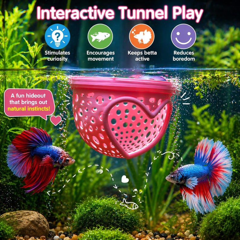 May include: A pink, heart-shaped aquarium hideout with a perforated design, suspended in a fish tank. The text "Interactive Tunnel Play" is at the top. Two colorful betta fish swim near the hideout. Text on the image says "Stimulates curiosity", "Encourages movement", "Keeps betta active", and "Reduces boredom".