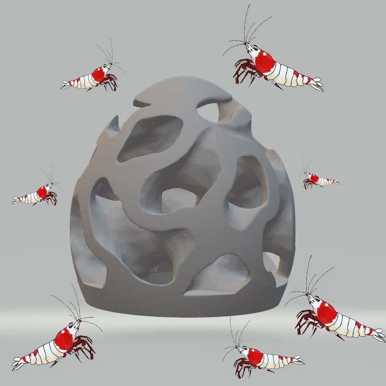 Puede incluir: Una estructura gris en forma de cueva con m&uacute;ltiples aberturas, rodeada de camarones rojos y blancos. Los camarones est&aacute;n en varias poses, algunos nadando, otros posados en la estructura.
