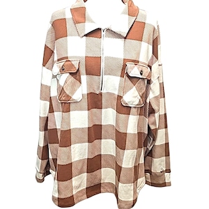 May include: Brown and white checkered long-sleeve shirt with a quarter-zip closure. The shirt features two front pockets with button closures and a collared neckline. The fabric has a soft, textured appearance.