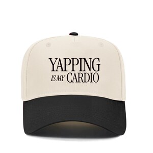 May include: A beige and black baseball cap with the text "YAPPING IS MY CARDIO" in black.