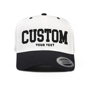 May include: White and black baseball cap with the word "CUSTOM" in black lettering and the words "YOUR TEXT" in smaller black lettering below.