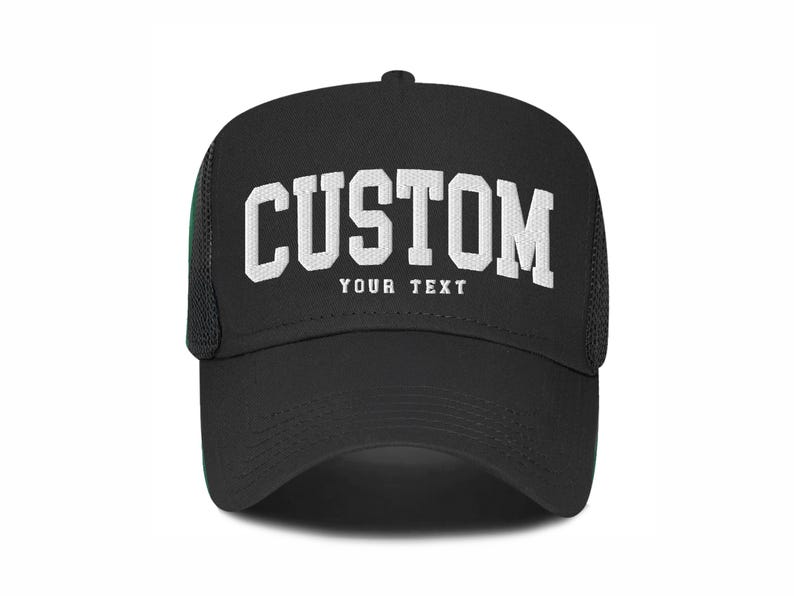 May include: Black trucker hat with white mesh back panel. The front of the hat has white text that reads "CUSTOM YOUR TEXT".