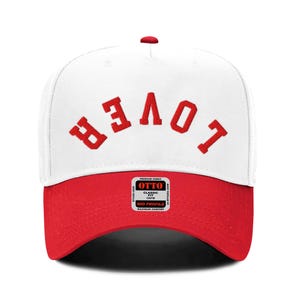 May include: A white and red baseball cap with the word "BELOVT" embroidered in red on the front.