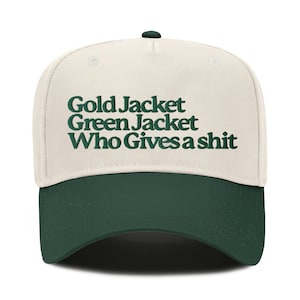 Puede incluir: Una gorra de béisbol beige y verde con el texto "Gold Jacket Green Jacket Who Gives a Shit" bordado en verde.