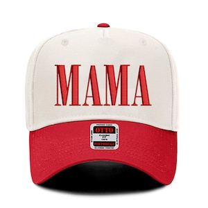 Pode incluir: Bon&eacute; de beisebol branco e vermelho com a palavra "MAMA" bordada em vermelho na frente. O bon&eacute; tem um ajuste cl&aacute;ssico e um perfil m&eacute;dio.