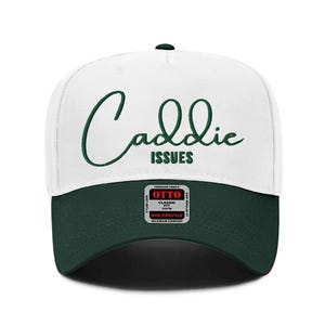 Può includere: Cappellino da camionista bianco e verde con il testo "Caddie Issues" ricamato in verde sul davanti. Il cappello ha una rete verde sul retro e una visiera nera.
