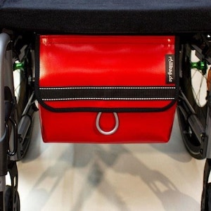 Rote Rollstuhltasche für vorn aus robuster LKW Plane. So kannst du selbst dein Handy und Wertsachen sicher, diskret verstauen und erreichen.