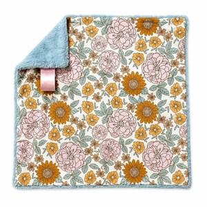 May include: A square baby blanket with a floral pattern on a white background featuring pink roses, mustard yellow sunflowers, and sage green leaves. The reverse side is a solid light blue faux fur fabric with a pink satin ribbon tag attached.