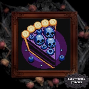 May include: A framed cross-stitch artwork shows a slice of pie with blueberry skulls. The pie crust is yellow, the filling is purple, and the blueberries and skulls are blue. The artwork is framed in a dark brown ornate frame. The text "FAES WITCHES STITCHES" is at the bottom.