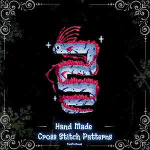 May include: A pixel art illustration of a long, serpentine creature with light blue scales and vibrant pink fins and crests, coiled in an S-shape. The design features small white four-pointed stars and the text Hand Made Cross Stitch Patterns FaesFortunes.