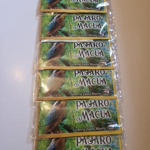 Puede incluir: Varios paquetes sellados del producto herbal 'Pajaro Macua'. Cada paquete presenta una ilustración de un pájaro y texto en español, incluyendo 'Yerberia Zanta Muerte' y 'Hecho en Mexico'.