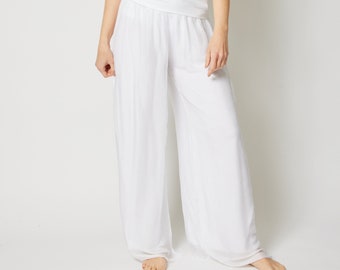 May include: White wide-leg pants with a wide elastic waistband. The pants are made of a lightweight, flowy fabric.