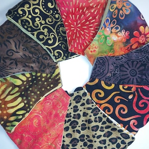 May include: A set of ten fabric face masks in various patterns, including floral, geometric, and animal print. The masks are all in shades of brown, red, black, and gold.