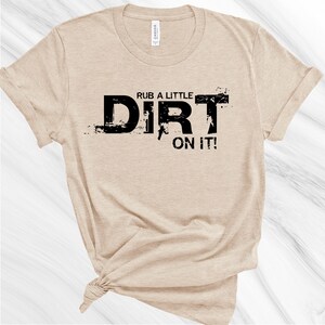May include: A tan t-shirt with black text that reads "Rub a little dirt on it!"