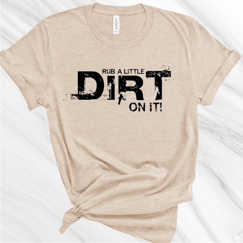 May include: A tan t-shirt with black text that reads "Rub a little dirt on it!"