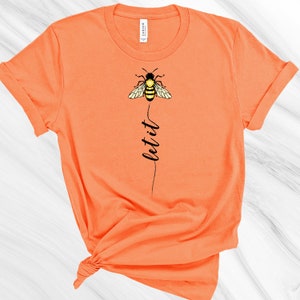 May include: Orange short-sleeved t-shirt with a black bee graphic and the text "let it" printed vertically below the bee.