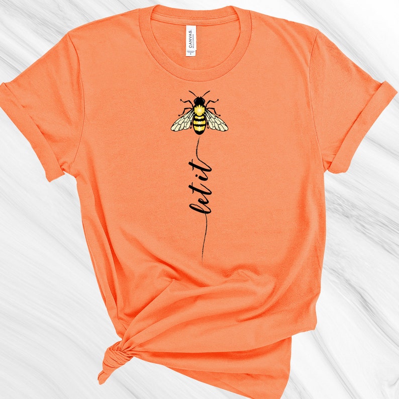 May include: Orange short-sleeved t-shirt with a black bee graphic and the text "let it" printed vertically below the bee.