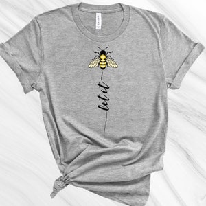May include: Gray t-shirt with a black and yellow bee graphic and the text "let it" printed vertically below the bee.
