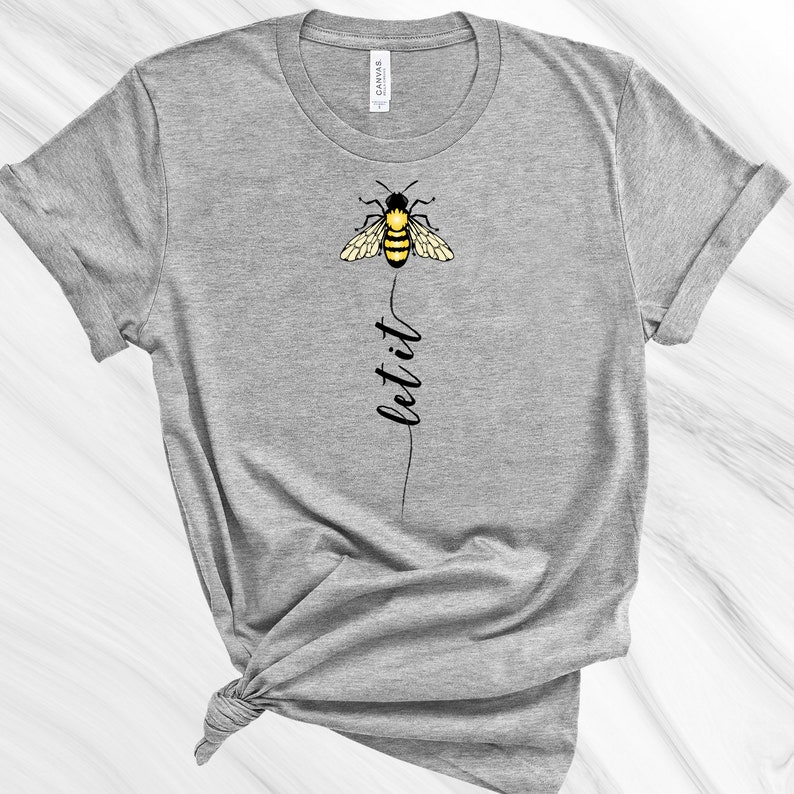 May include: Gray t-shirt with a black and yellow bee graphic and the text "let it" printed vertically below the bee.