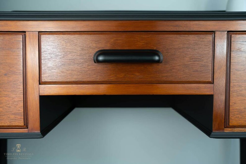 May include: A wooden desk with a black painted top and a drawer with a black pull handle. The desk has a shelf underneath the drawer.