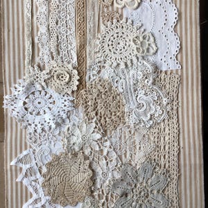 May include: An assortment of vintage lace doilies, trims, and floral appliqués in cream and beige tones. The delicate pieces are displayed on a striped fabric background, featuring intricate crochet and openwork patterns. Suitable for crafting and vintage-inspired projects.