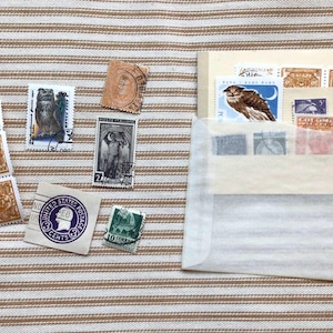 10 Postage stamps tucked in a vintage stock card and old glassine envelope. Seven of the stamps are actual postage stamps.