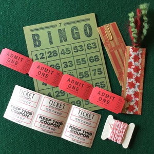 May include: A green bingo card with numbers 12, 28, 45, 53, 63, 26, 33, 55, 68, 58, 75, 4, 29, 65, and 9. There are four red and white admit one tickets. There are three white tickets that say "Keep this coupon" and have a ticket number. There is a spool of red and white twine and a bookmark with a red and white poinsettia pattern.