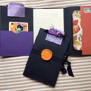 Mini journal with pockets, an embellished paper clip, seam binding closure and a wax seal.