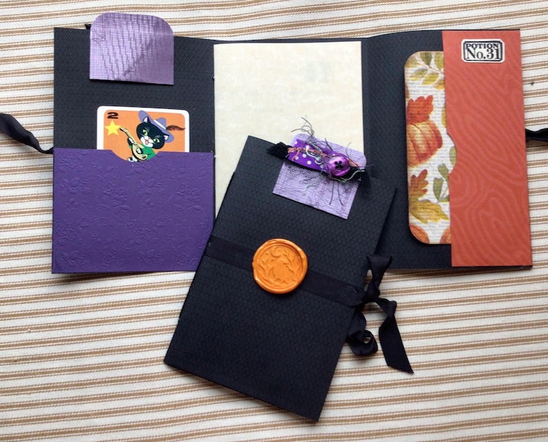 Mini journal with pockets, an embellished paper clip, seam binding closure and a wax seal.