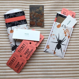Double pocket made from a silverware sleeve is filled with 6 orange tickets, a vocabulary card, and other ephemera.