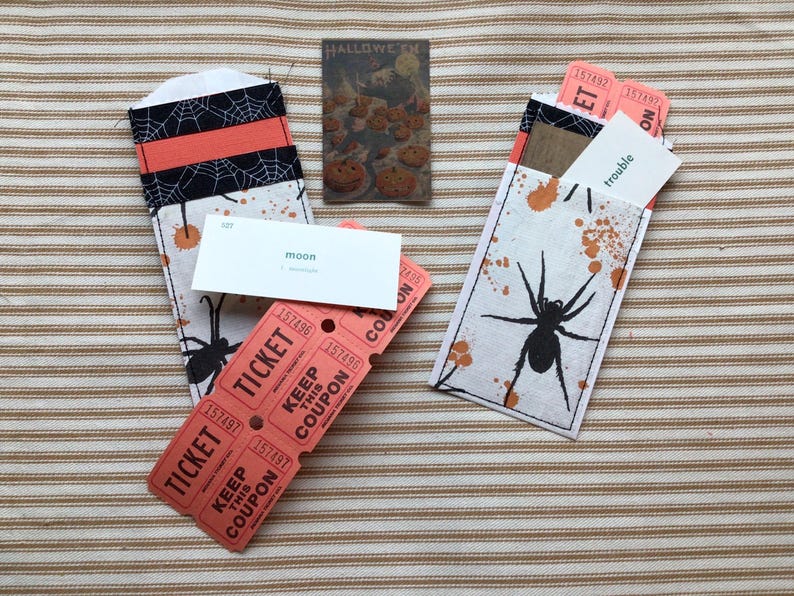 Double pocket made from a silverware sleeve is filled with 6 orange tickets, a vocabulary card, and other ephemera.