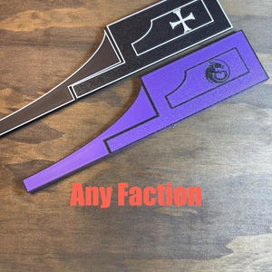 May include: Two decorative wooden game pieces, one black with a white cross, the other purple with a dragon symbol. The text "Any Faction" is printed in red below the pieces.