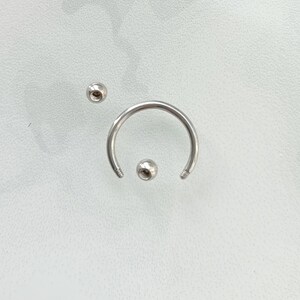 Pu&ograve; includere: Un set di gioielli per il corpo in argento con una barra circolare e due estremit&agrave; a sfera.