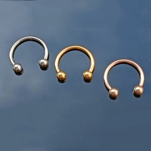 Pu&ograve; includere: Tre anelli a forma di ferro di cavallo con estremit&agrave; a sfera. Gli anelli sono argentati, dorati e oro rosa.