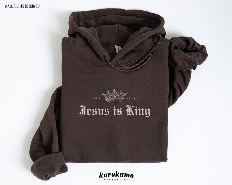 May include: A brown hoodie with a crown and the text "Jesus is King" in a vintage font. The text "Rev. 17:14" is above the crown.