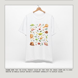 May include: White t-shirt with a pattern of brown snails and green leaves. The text "COLOR OPTIONS" is at the top of the image. The text "MESSAGE US IF INTERESTED IN ANOTHER COLOR NOT SHOWN" is at the top right of the image. The text "PLEASE NOTE THAT THE ACTUAL PRODUCT COLOR MAY VARY FROM THE IMAGES SHOWN DUE TO EVERY MONITOR OR MOBILE DISPLAY HAVING A DIFFERENT CAPABILITY TO DISPLAY COLORS." is at the bottom of the image. The text "COPYRIGHT" is at the bottom left of the image. The text "kurokumo APPAREL CO" is in the center of the image. The text "ALL RIGHTS RESERVED" is at the bottom right of the image.