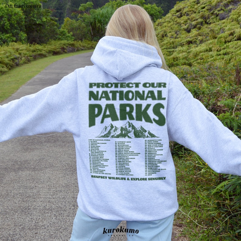May include: A light gray hoodie with the text "PROTECT OUR NATIONAL PARKS" in green, along with a mountain graphic. The back of the hoodie also lists various national parks. The phrase "RESPECT WILDLIFE & EXPLORE SENSIBLY" is printed at the bottom.