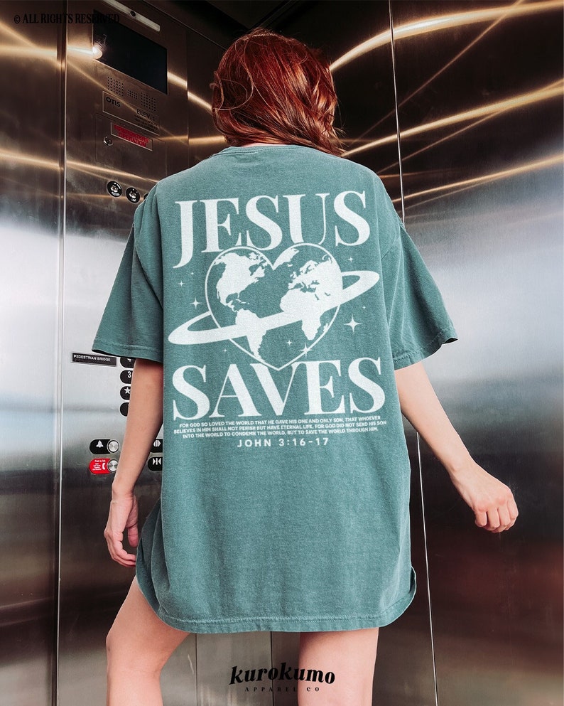 K&ouml;nnte beinhalten: &Uuml;berdimensioniertes T-Shirt in Tealblau mit einem wei&szlig;en Grafikdruck eines Herzens mit einem Globus darin und einem Ring darum. Der Text "JESUS SAVES" ist &uuml;ber dem Grafikdruck gedruckt und der Text "FOR GOD SO LOVED THE WORLD THAT HE GAVE HIS ONE AND ONLY SON, THAT WHOEVER BELIEVES IN HIM SHALL NOT PERISH BUT HAVE ETERNAL LIFE. FOR GOD DID NOT SEND HIS SON INTO THE WORLD TO CONDEMN THE WORLD, BUT TO SAVE THE WORLD THROUGH HIS SON. JOHN 3:16-17" ist unter dem Grafikdruck gedruckt.