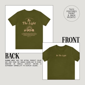 May include: A green t-shirt with a peach colored graphic print on the front and back. The front print says "Be The Light" and the back print says "In this dark world, Be The Light".