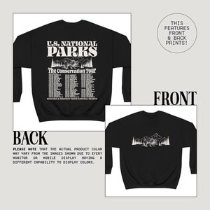 May include: Black sweatshirt with a front graphic featuring "U.S. National Parks" text, a bear, and mountain scene. The back graphic shows a similar mountain and bear design. The text "The Conservation Tour" is also present.
