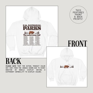 Pu&ograve; includere: Felpa con cappuccio bianca con stampe anteriori e posteriori. Il retro presenta il testo "U.S. National Parks", una grafica di orso e i dettagli del tour. Il davanti mostra un orso con alberi e montagne. La felpa ha un cappuccio con coulisse.
