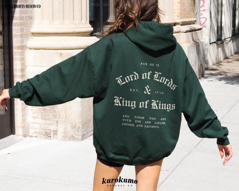 May include: A dark green hooded sweatshirt with the text "FOR HE IS Lord of Lords REV. & King of Kings AND THOSE WHO ARE WITH HIM ARE CALLED, CHOSEN, AND FAITHFUL" printed on the back.