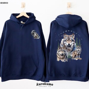 May include: A navy blue hooded sweatshirt with a wolf howling at the moon graphic on the left side and a group of wolves in a forest scene on the right side.