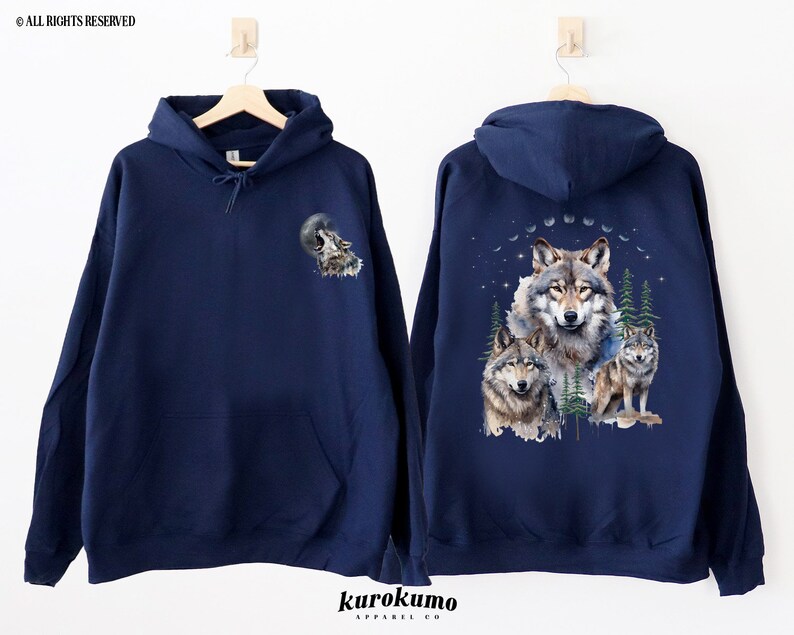 May include: A navy blue hooded sweatshirt with a wolf howling at the moon graphic on the left side and a group of wolves in a forest scene on the right side.
