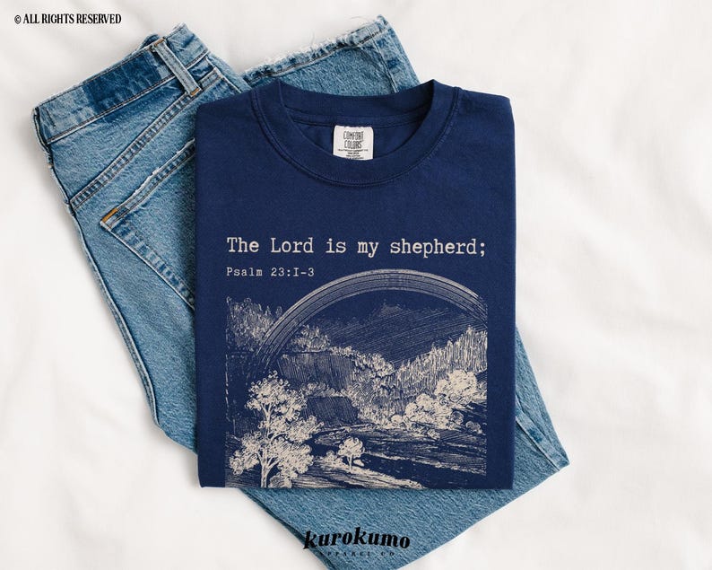 Puede incluir: Una camiseta azul marino con un gr&aacute;fico blanco de un paisaje y el texto "The Lord is my shepherd; Psalm 23:1-3".