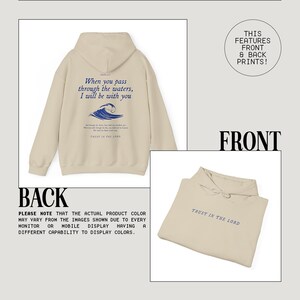 May include: Beige hooded sweatshirt with a blue wave graphic and the text "When you pass through the waters, I will be with you" and "Trust in the Lord". The back of the sweatshirt has the text "Trust in the Lord" in blue.